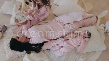 母亲和女儿穿着粉红色睡衣的新生婴儿在平安夜